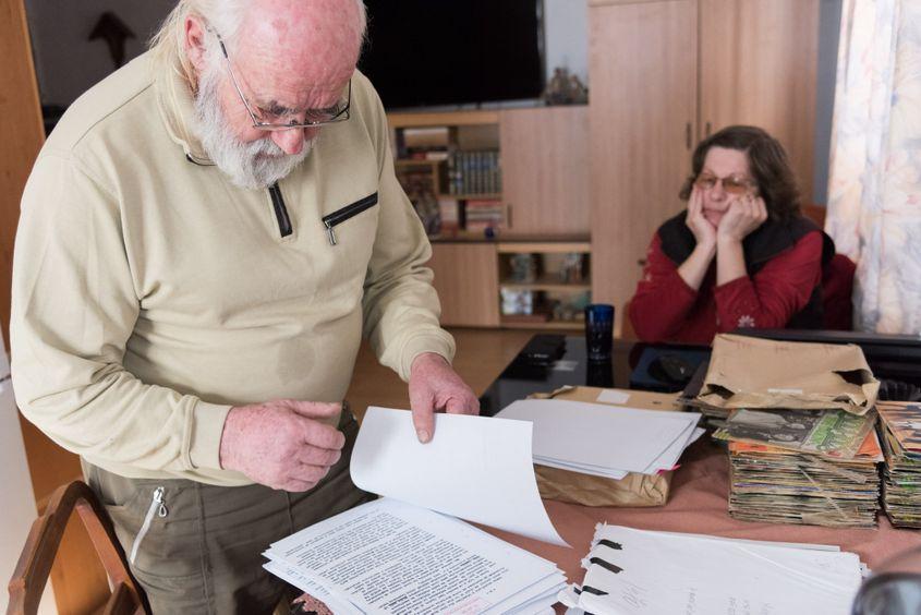 Emil Hidoş îşi răsfoieşte dosarul de la Securitate, sub privirile soţiei sale. Foto: Raul Ştef
