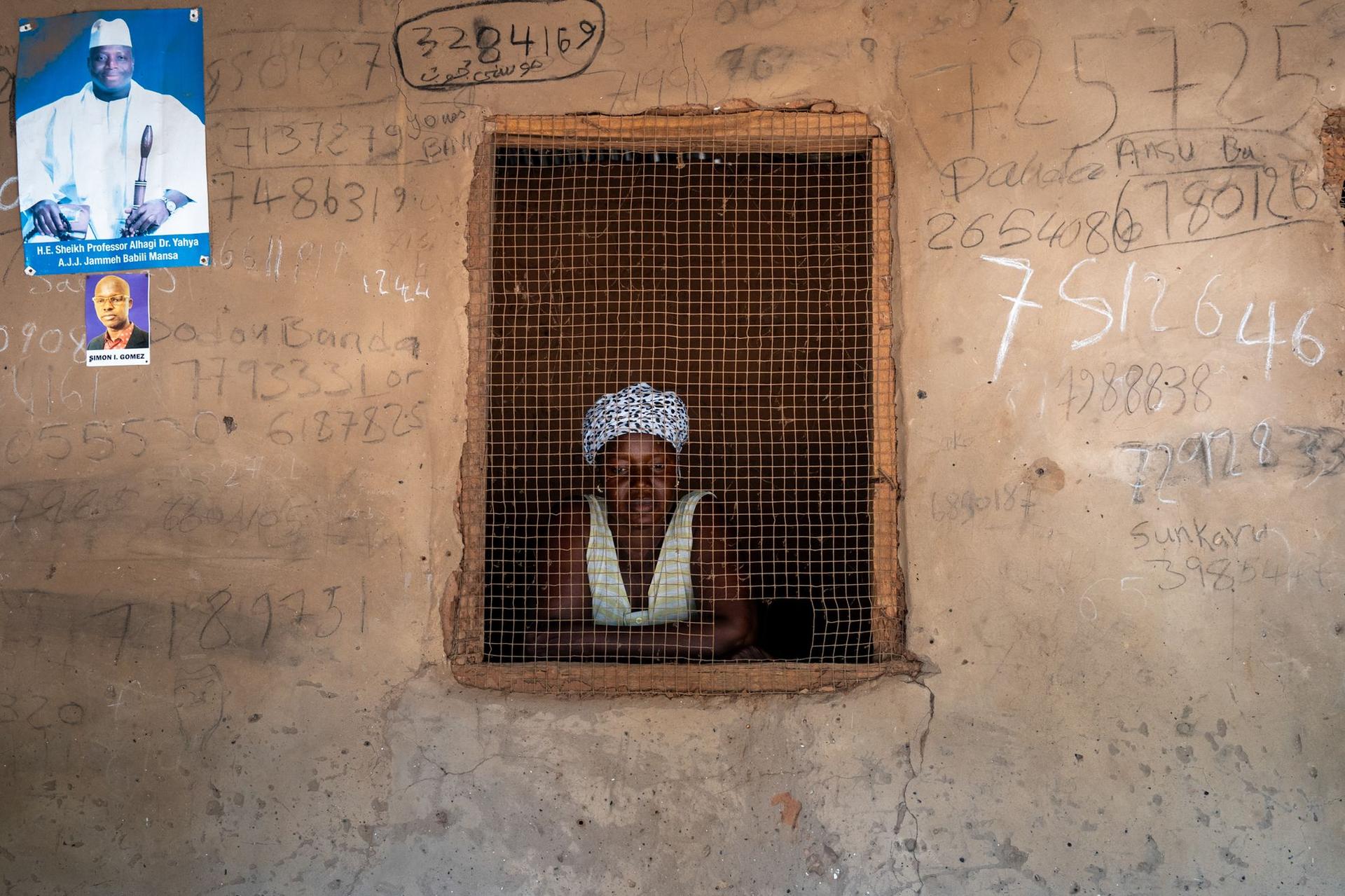 Fatou în casa ei din Kayanga. Pe perete un poster cu fostul dictator Yahya Jammeh. Foto: Andrei Popoviciu