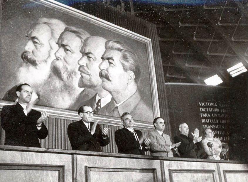 1951, România. Un prezidiu cu oficiali comuniști, sub portretele lui Marx, Engels, Lenin şi Stalin. Sursa: Fototeca online a comunismului românesc.