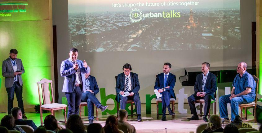 Anunţul înfiinţării Alianţei Vestului a fost făcut în toamna lui 2018, la conferinţa Urban Talks organizată de UrbanizeHub. Primul din stânga este Graţian Mihăilescu, la microfon e rectorul Universităţii de Vest, Marilen Pirtea, iar în planul doi, pe scaune, sunt Ilie Bolojan (primarul din Oradea), Nicolae Robu (Timişoara) şi Gheorghe Falcă (Arad).