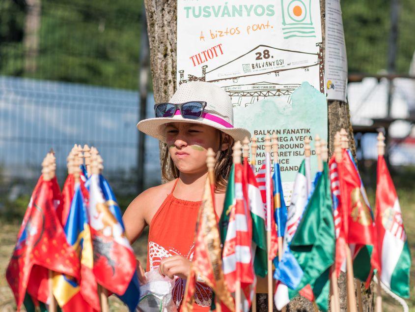 O fetiță vinde steaguri cu însemne ungurești și secuiești la festivalul Tusványos din Harghita în 2017. FOTO: Raul Ștef (c)