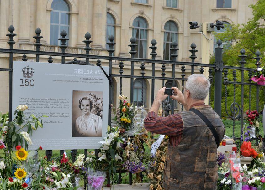 În fața Palatului Regal din Capitală, un bărbat fotografiază imaginea reginei Ana. Foto: Iulia Marin