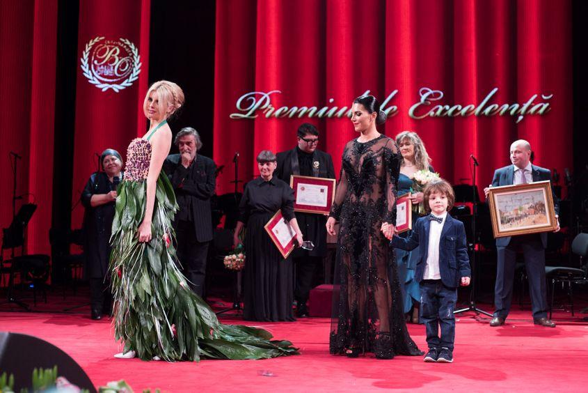 Florina Bogdan, de mână cu fiul ei, a primit ultimul premiu al serii. În stânga şi în verde, creaţia ei florală.