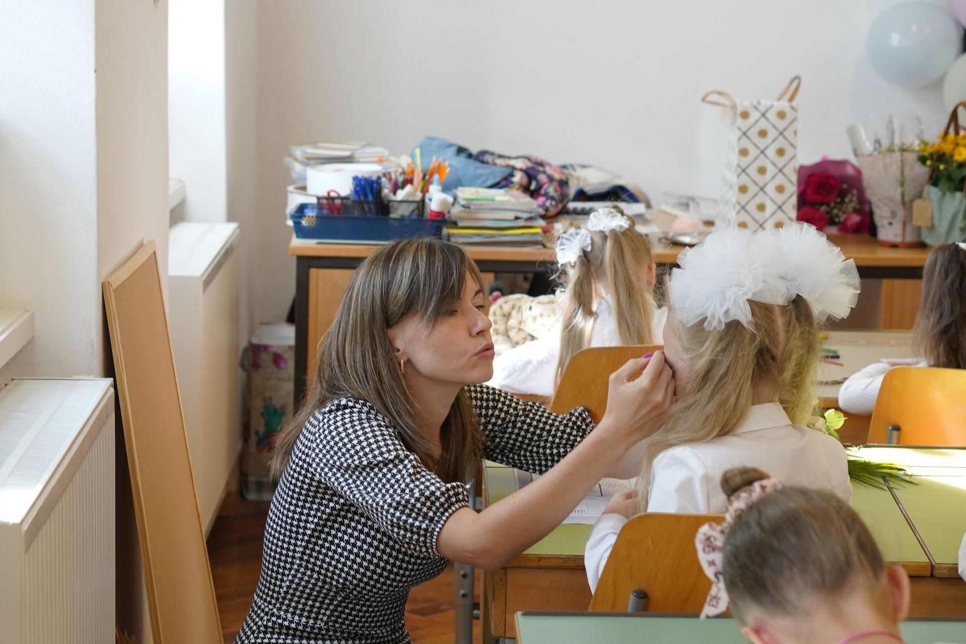 Katerina Mikolaevna Popova, învățătoare la clasa I, alină o elevă care plânge, în prima zi de școală. Foto: Andreea Câmpeanu