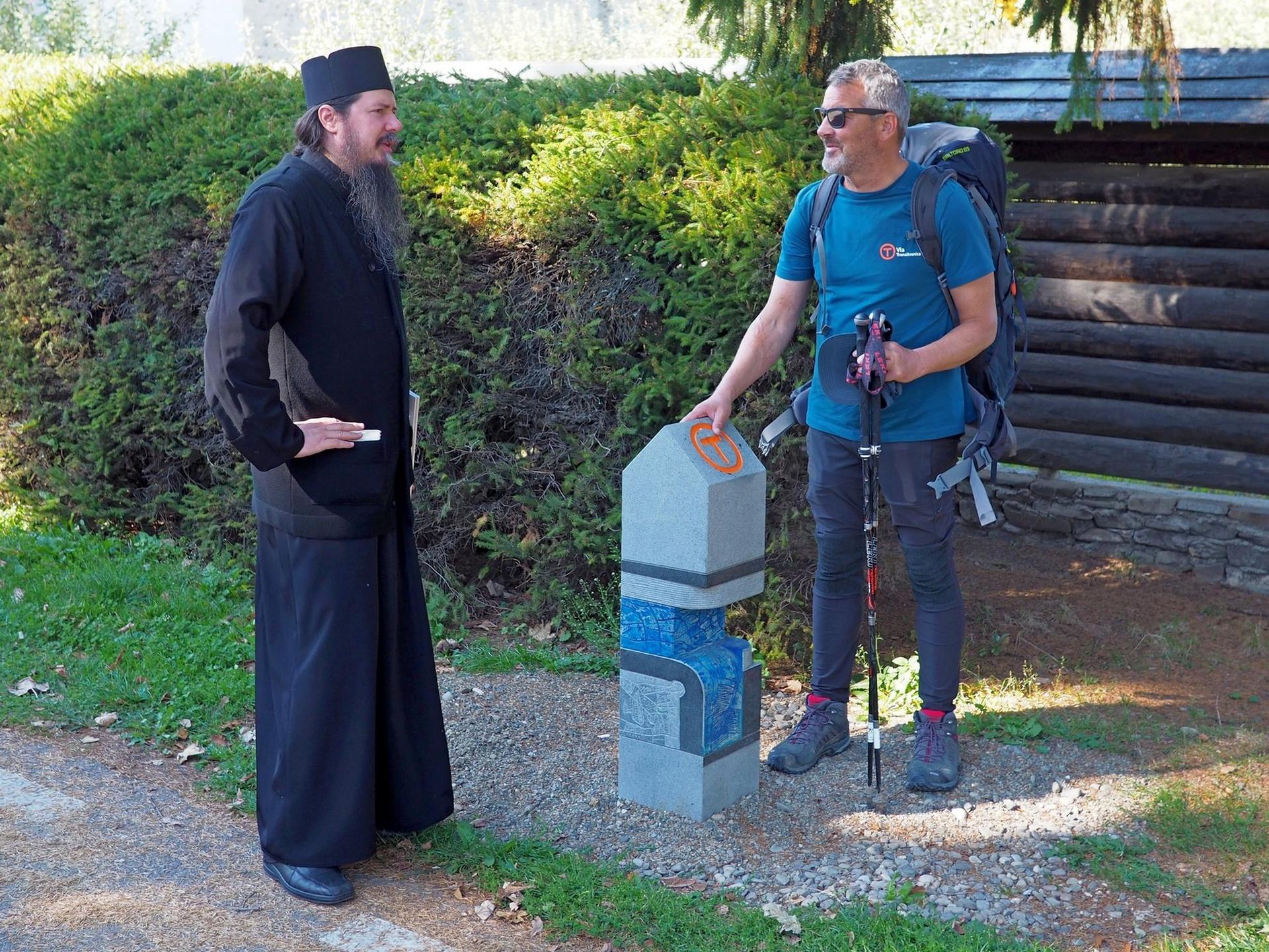 În octombrie 2019 la piatra de hotar din fața mănăstirii Putna, Alin stă de vorbă cu părintele Dosoftei înainte de o nouă tură de Bucovina