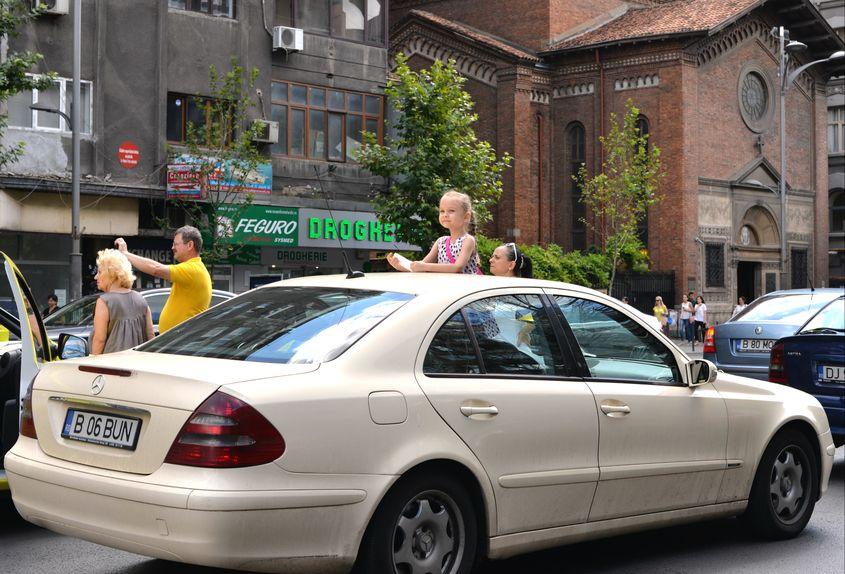 O fetiță privește, din mașină, cortegiul funerar. Foto: Iulia Marin