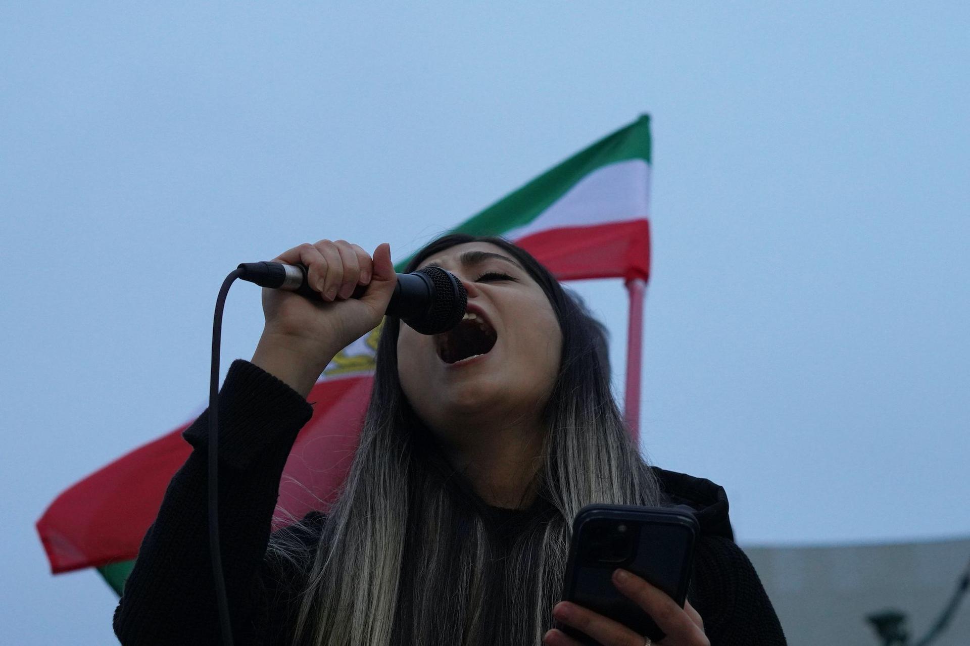 O tânără din comunitatea iraniană din București scandează în timpul unui protest prin care membrii comunității vor să aducă în atenția opiniei publice ce se întâmplă momentan în Iran, în Parcul TNB, în București, pe 15 octombrie 2022.