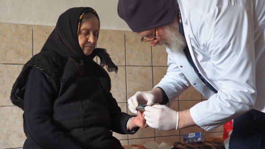 Doctorul Ciubotărescu îi ia lelei Rafila sânge din deget ca să-i afle glicemia.