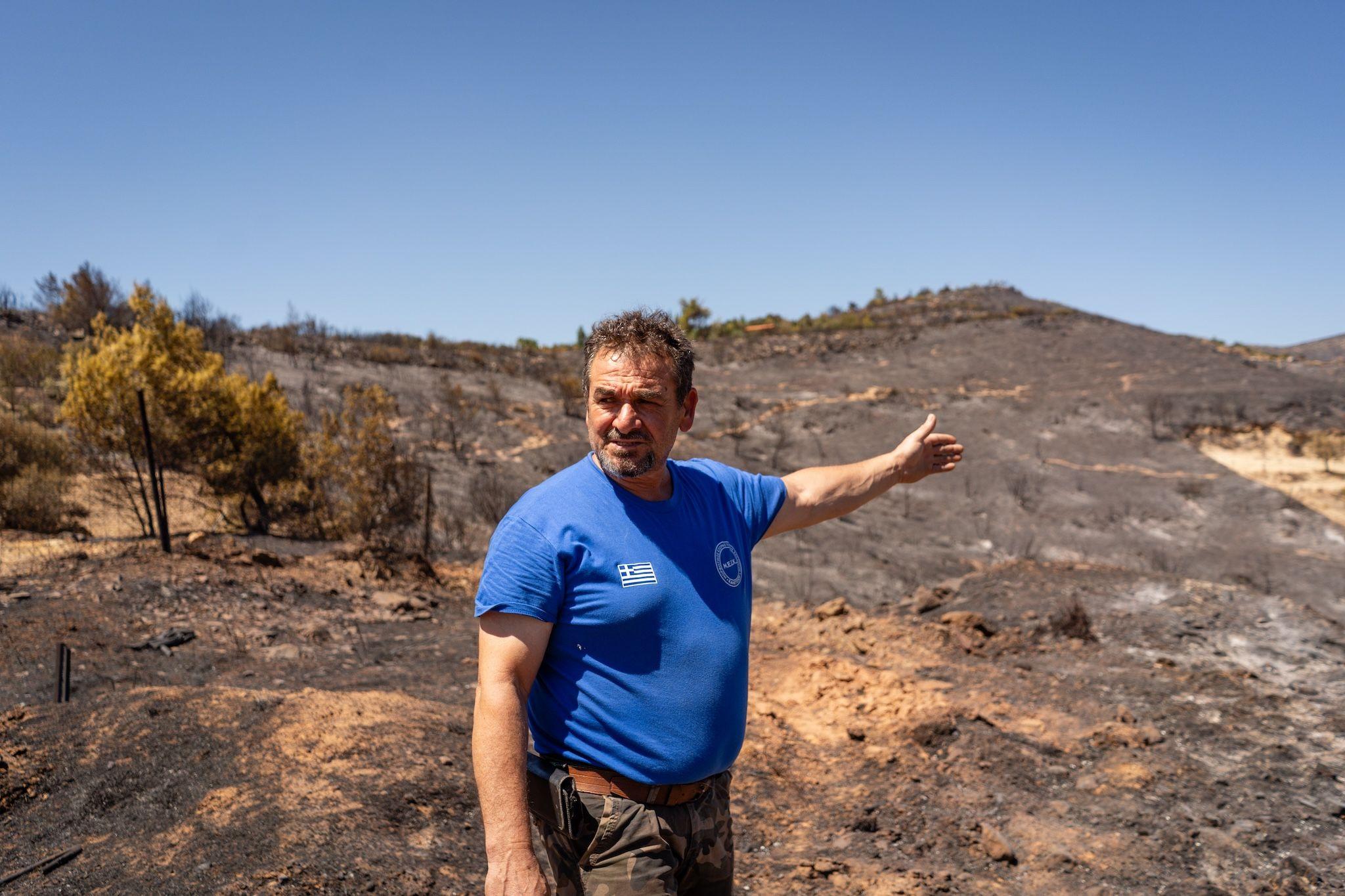 Christos Masouras, the villager from Kalentzi, Marathonas, points to the path of destruction left by the wildfire in Nea Makri, Athens, on August 13, 2024. Photo: Ioana Epure