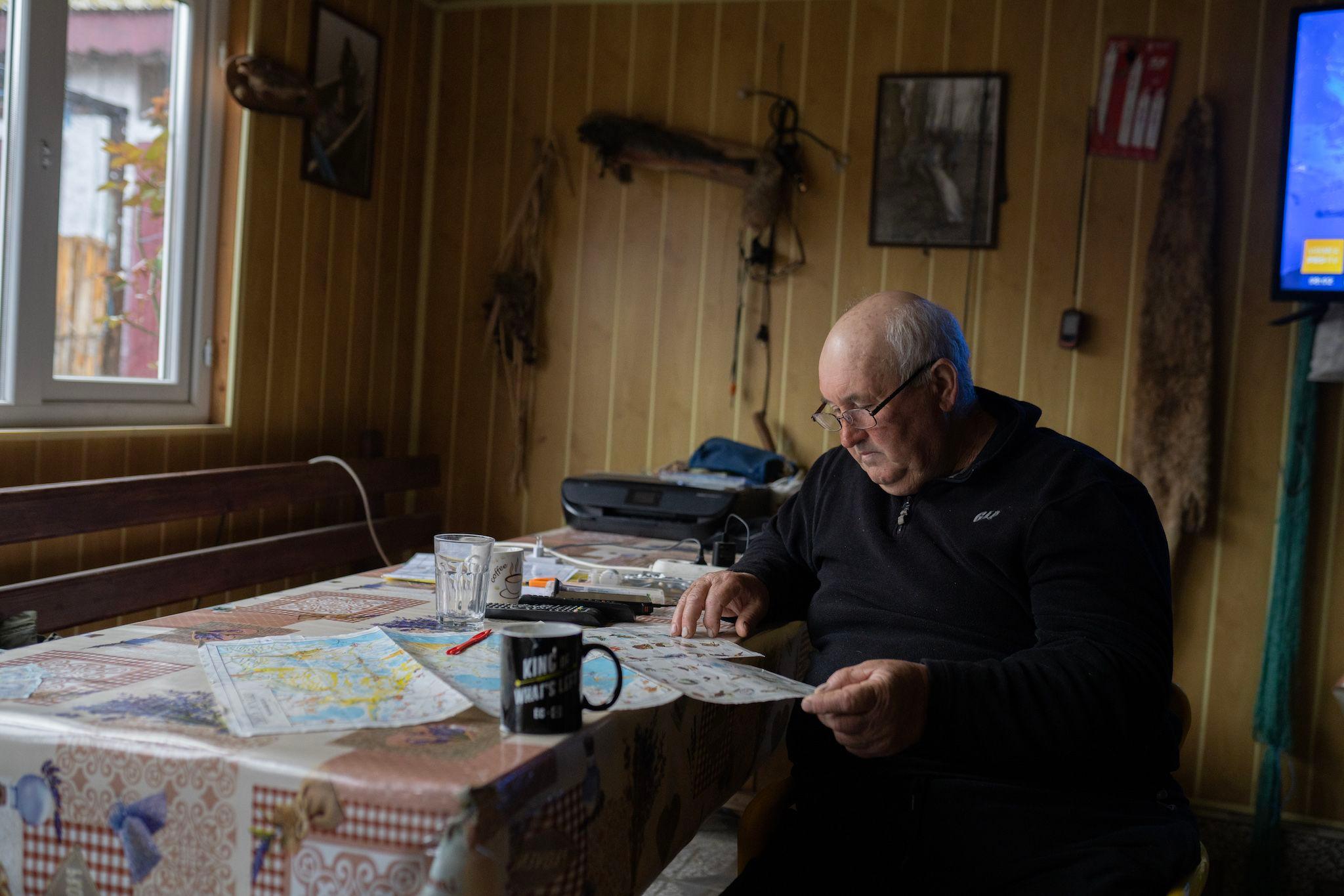 Nicu Efimov se uită la o hartă a Deltei Dunării, în Sfântu Gheorghe. Foto: Andreea Câmpeanu