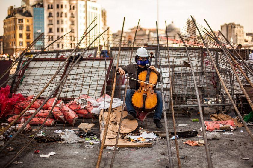 Un tânăr cântă la violoncel așezat într-o baricadă a protestatarilor din Taksim Square, Istanbul. Sâmbătă, 15 iunie 2013. Fotografie: Ovidiu Micsik / Inquam Photos