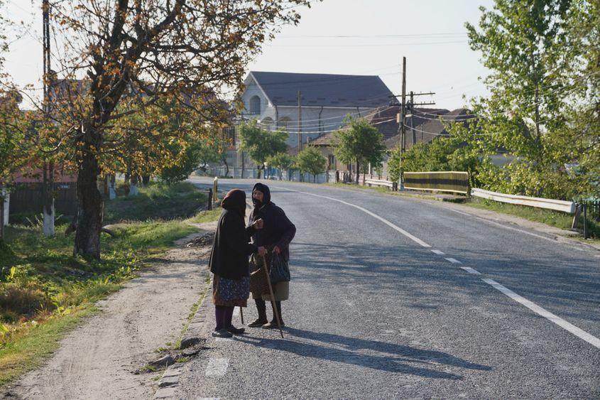 Cu declarațiile împachetate în ilice, două bătrâne se întâlnesc în sat, în afara intervalului 11:00-13:00. Aveau nevoie de apă de la cișmele și de brânză de la o vecină. Foto: Maria Tufan