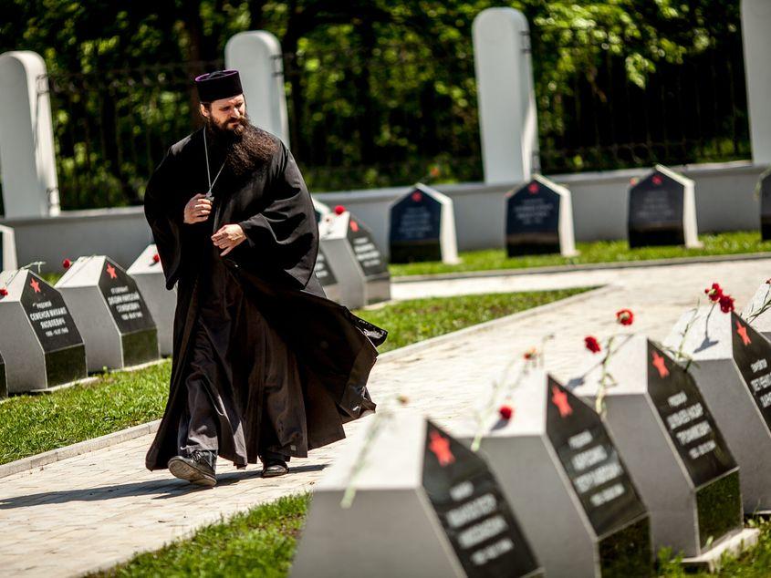 Un preot paseste printre pietrele comemorative dupa ceremonia de depunere de coroane de flori organizata de ambasada Rusiei in Romani, 8 Mai 2015. Foto: Ovidiu Micsik / Inquam Photos