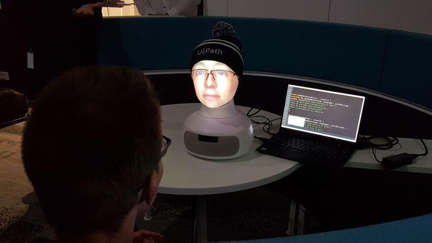 Oamenii simt nevoia să interacționeze cu un robot cu față umană, care învață din întrebările lor. În imagine, robotul social de la UiPath.
