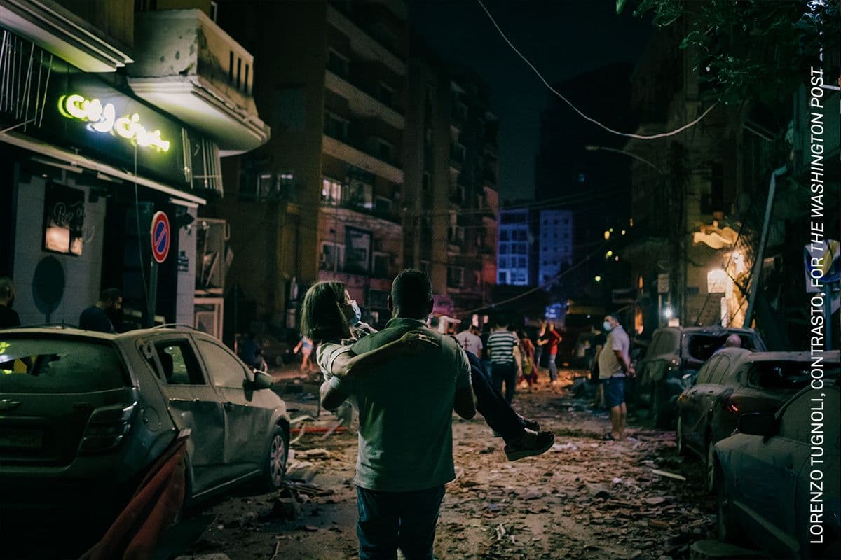 O femeie este dusă spre spital în Gemmayzeh, Beirut, un cartier predominant creștin, cu o mare concentrație de clădiri vechi. După explozia catastrofală din 4 august, străzile erau blocate de moloz iar mașinile nu-și puteau face loc, așa că mulți dintre răniți au fost cărați pe brațe spre spital sau alte zone mai sigure ale orașului. Foto: Lorenzo Tugnoli / The Washington Post