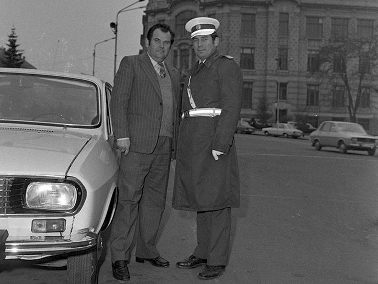 Milițian și activist lângă Dacie în fața Casei de cultură a studenților