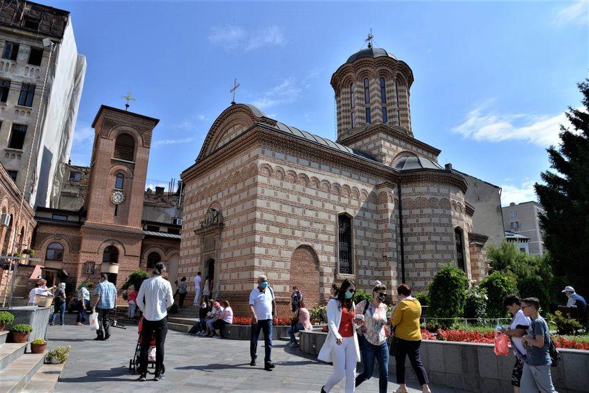 Credincioșii participă la slujba religioasă în afara bisericii și în curte, încercând să poarte mască și să păstreze distanțarea socială la Bisericii Curtea Veche din București. Foto: Lucian Muntean