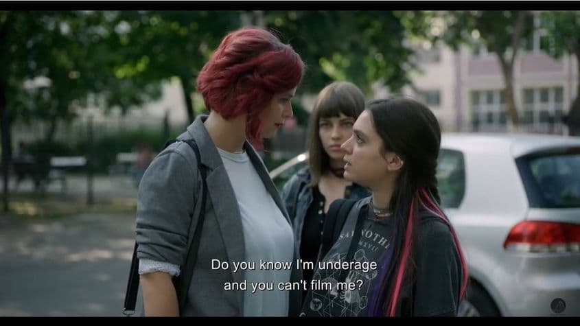Diana Cavallioti (stânga) în rol de jurnalistă dispusă să hărțuiască minori pentru a expune homofobia autorităților. Screenshot via <a target="_blank" href="https://www.youtube.com/watch?v=83hIpNEFBqw&ab_channel=ROLLERCOASTERPRROLLERCOASTERPR">Youtube</a>