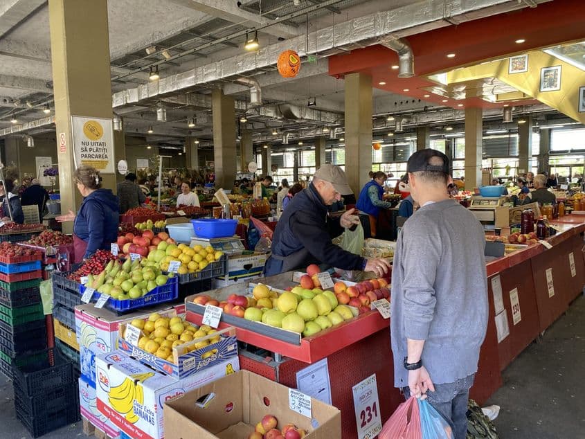 Vânzătorii din piață se grăbesc să servească când în strânga, când în dreapta. Foto: PressOne