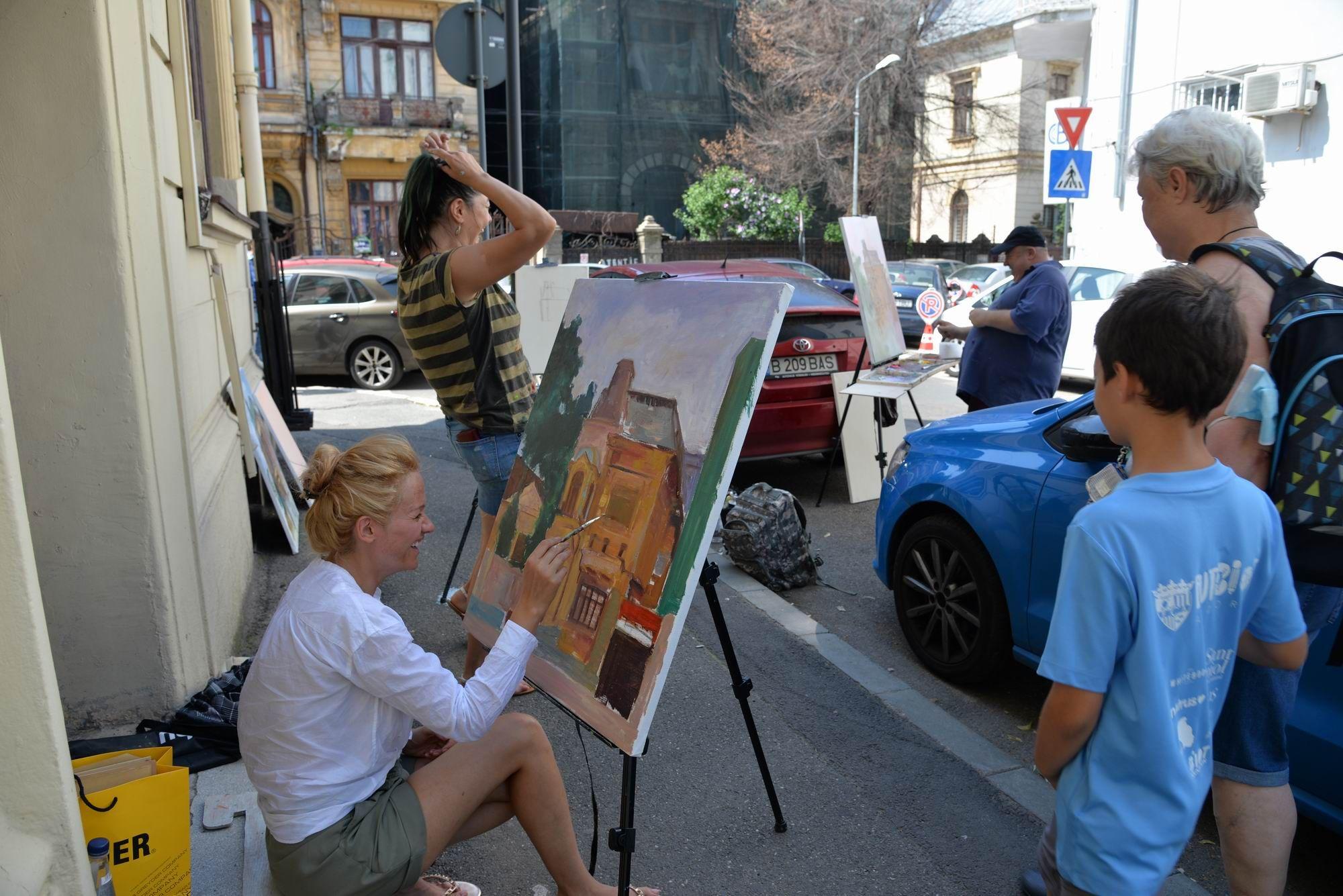 Artiștii pictează între mașini pe strada Ion Luca Caragiale din București. Foto Lucian Muntean
