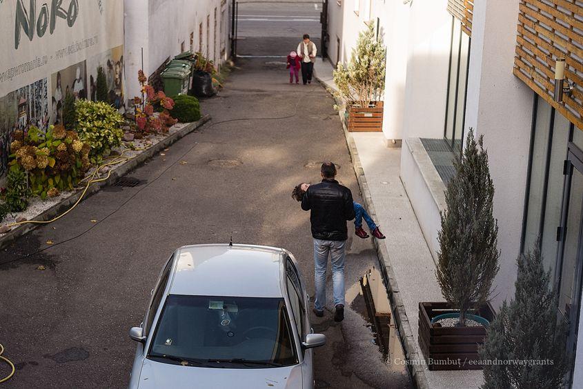 Tată Irinei o duce pe fiica lui la mașină după ședința de ergoterapie.