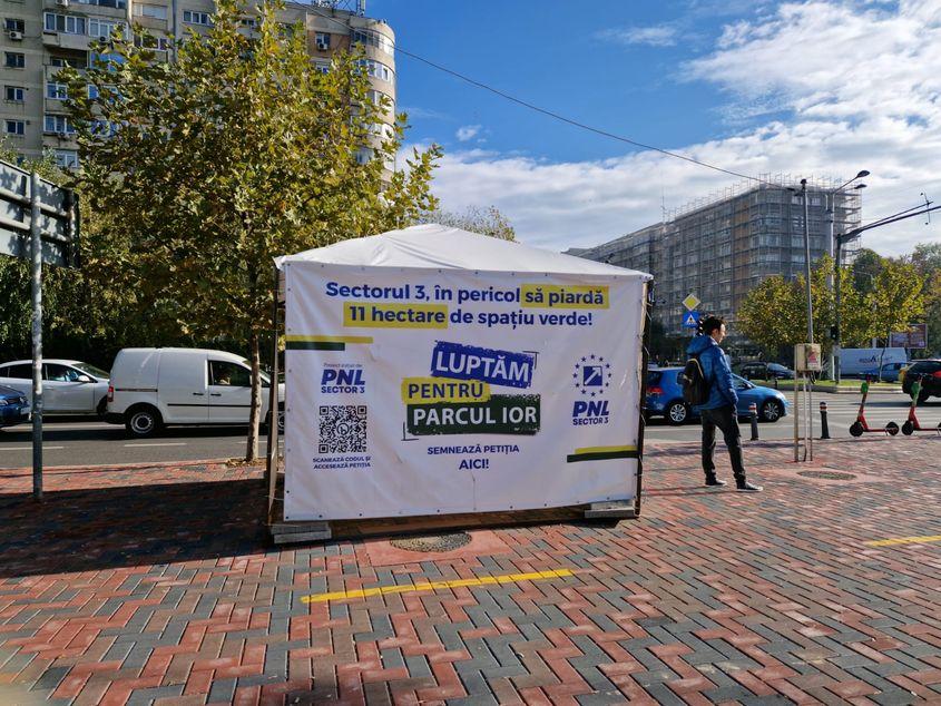 „Luptăm pentru parcul IOR. Semnează petiția AICI”, scrie pe un cort acoperit de culorile și simbolurile Partidului Național Liberal (PNL) montat lângă stația de metrou Titan.