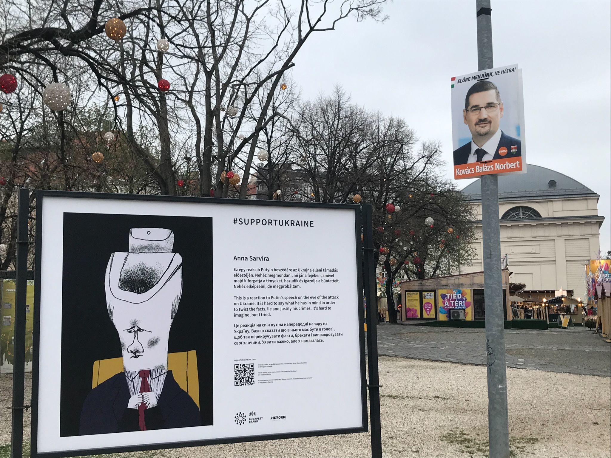 Un afiș cu un candidat pe listele Fidesz, chiar lângă un panou cu o caricatură a lui Putin, în cadrul unei expoziții de solidarizare cu Ucraina
