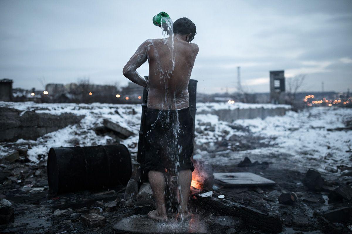 Un migrant afgan își spală corpul lângă un depozit abandonat din apropierea gării centrale din Belgrad, Serbia, la 19 ianuarie 2017. Foto: Konstantinos Tsakalidis