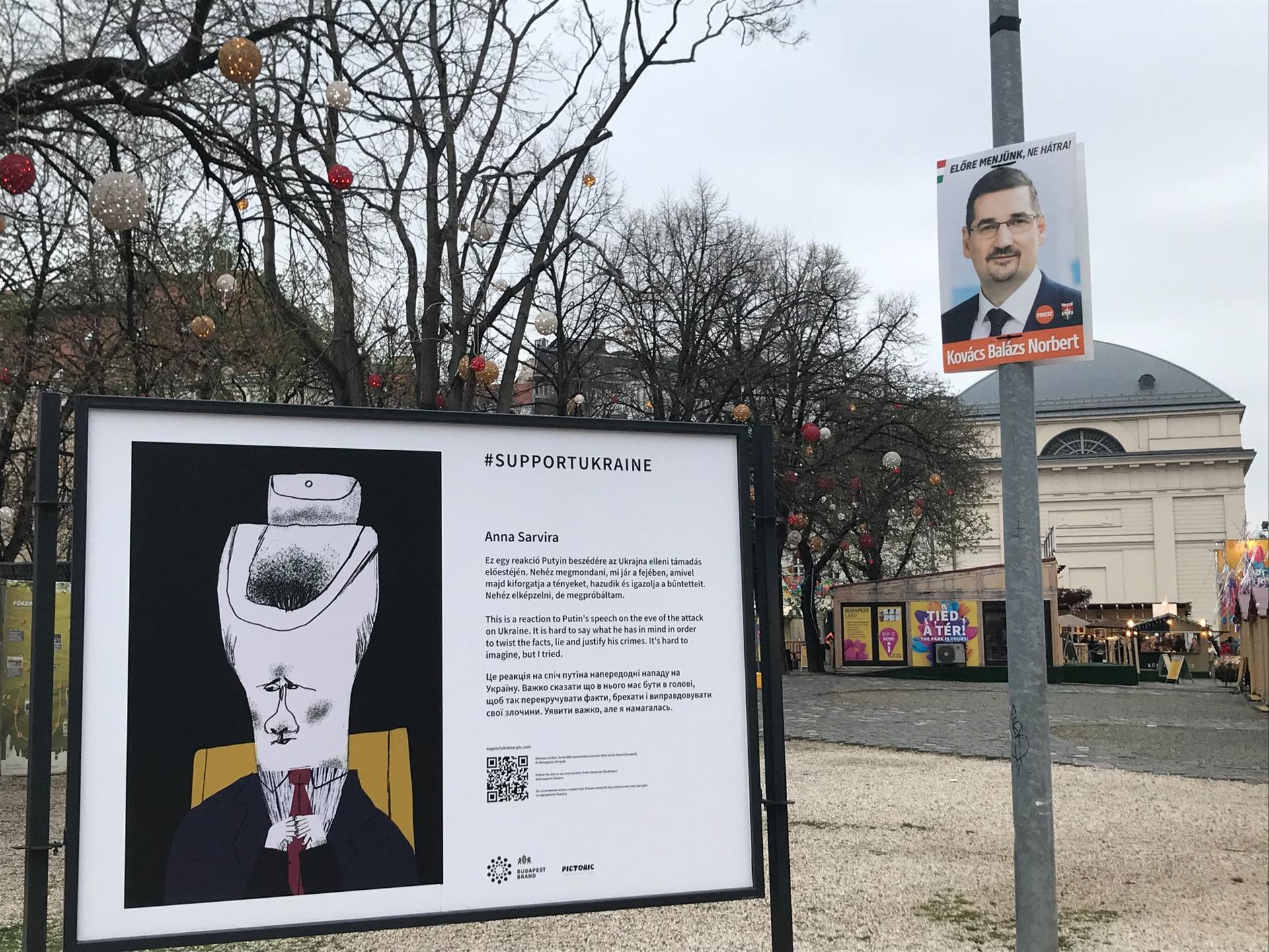 Un afiș cu un candidat pe listele Fidesz, chiar lângă un panou cu o caricatură a lui Putin, în cadrul unei expoziții de solidarizare cu Ucraina