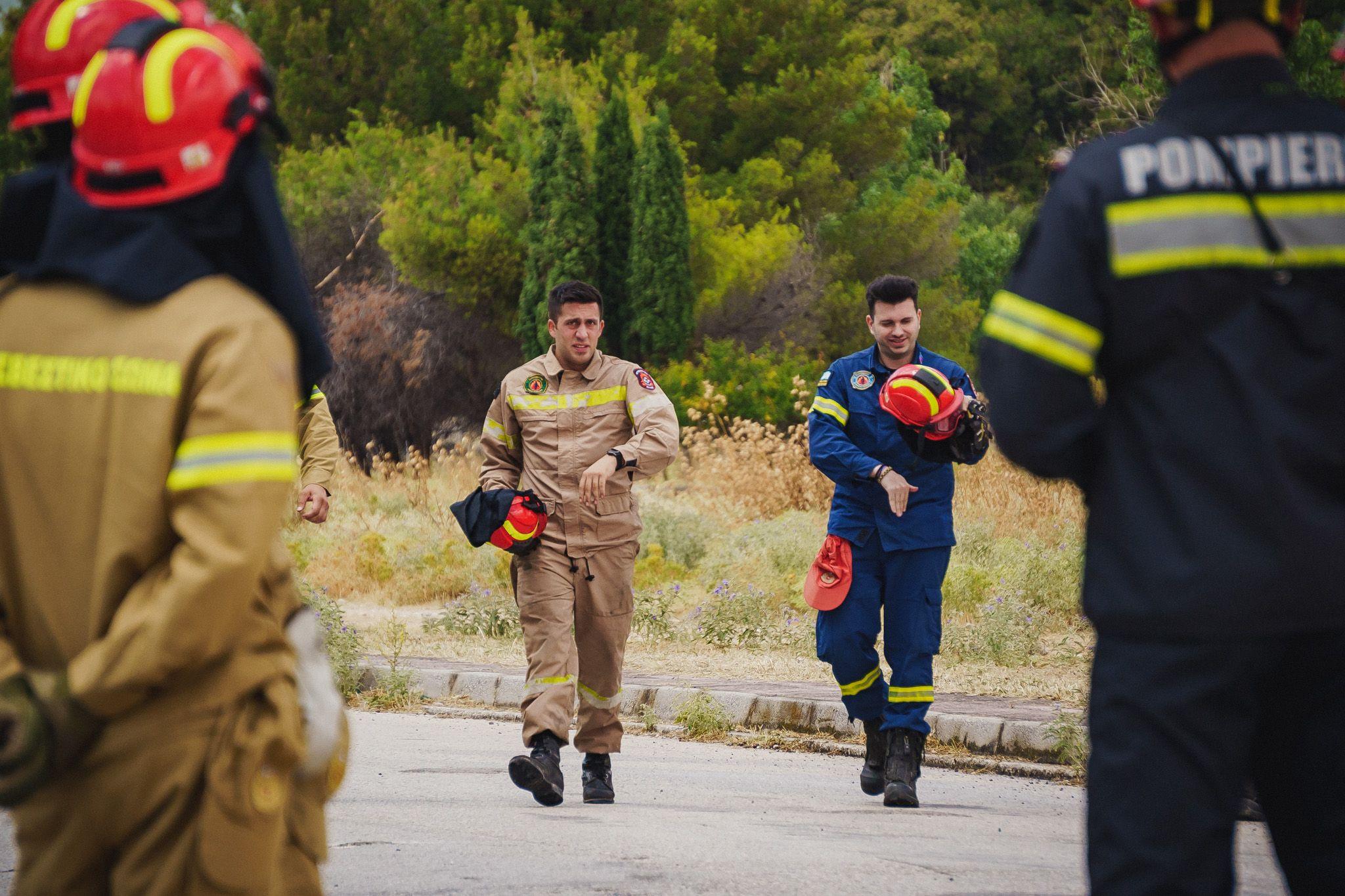 Doi pompieri eleni participă la un exercițiu de stingere a incendiilor în Atena. Foto: Ioana Epure