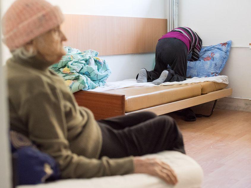 O femeie se roagă în patul ei de la Centrul de Îngrijire și Asistență "Acoperământul Maicii Domnului" din Turda. Fotografii: Raul Ştef