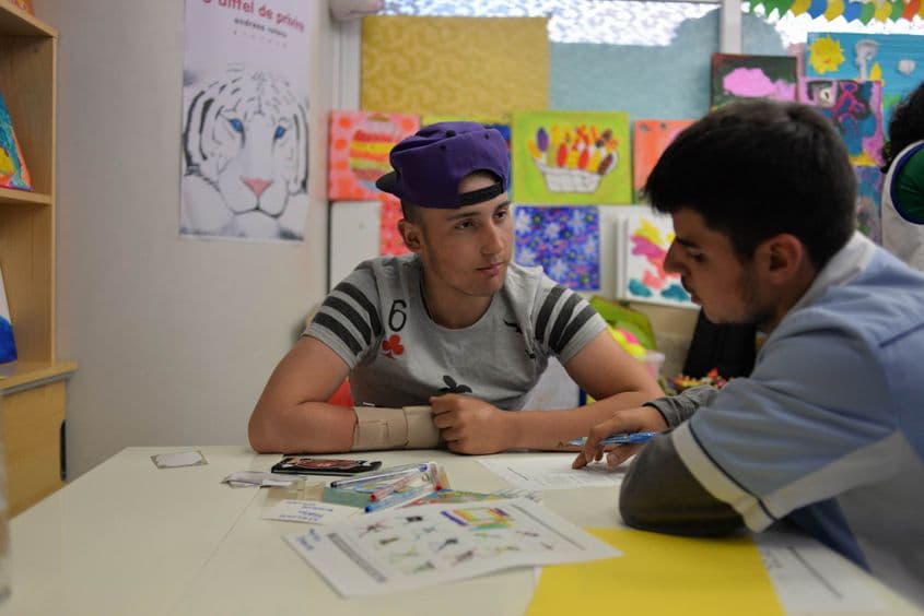 Iulian (în stânga) are 17 ani și este elev în clasa a XI-a. Stelian are 27 de ani și este terapeut ocupațional și profesor de engleză la Școala de spital.