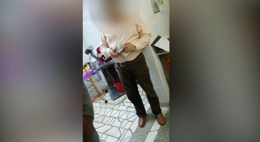 Doctorul Burciu, numărând banii pe care voia să îi dea înapot familiei, în timp ce echipajul Serviciului de Ambulanţă Prahova încă încerca să resusciteze femeia. Foto: captură din video via Adevărul.ro