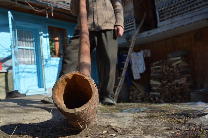 De 20 de ani, nimeni nu i-a mai cerut buciume lui moș Micu. Cel din imagine e ultimul pe care l-a făcut. Celelalte instrumente pe care le păstrase au ars în 1990, împreună cu toată gospodăria. Atunci a rămas doar cu o vacă, o capră și un stog de fân.