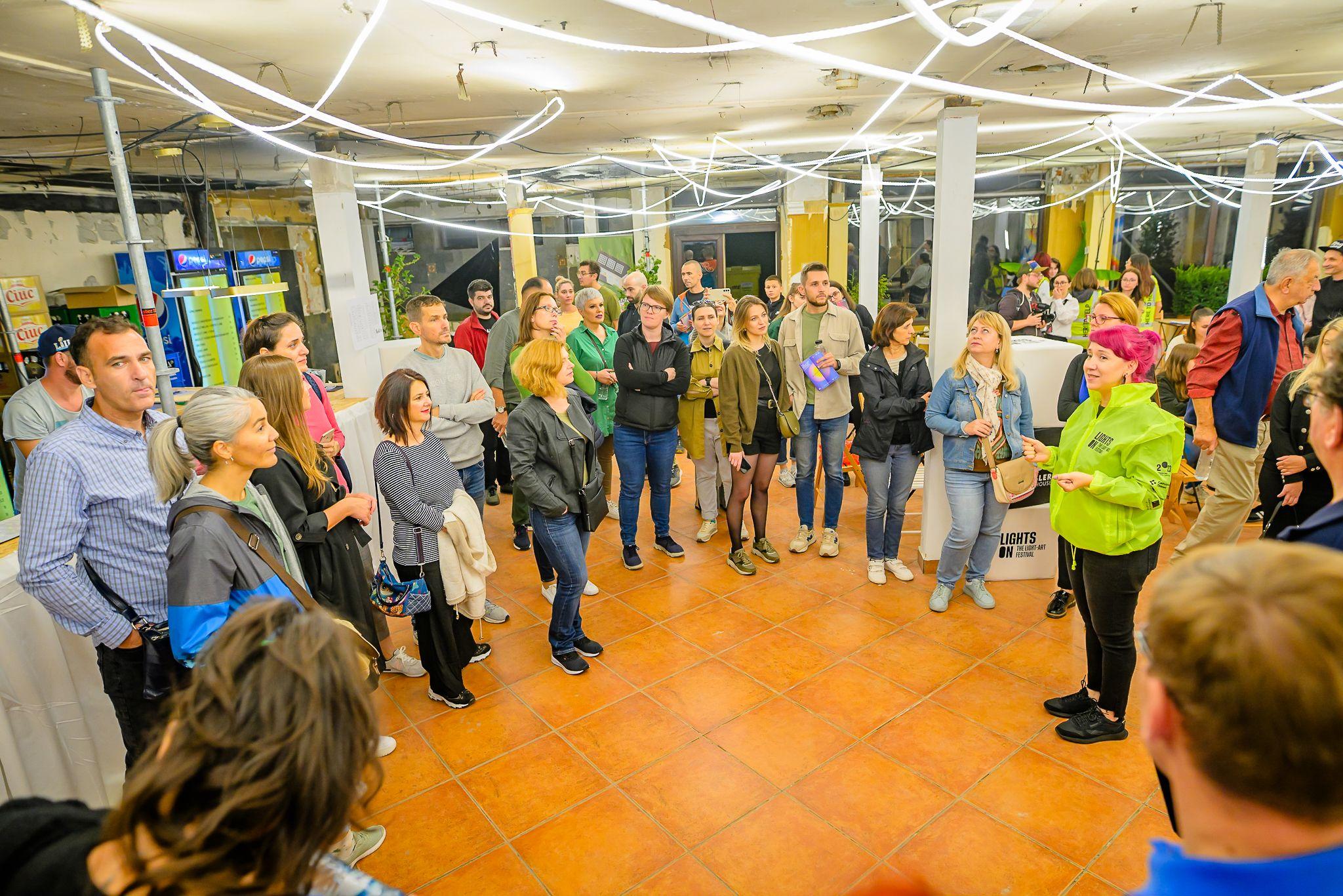 Primul Night Walk cu Alexandra de la Timișoara Tour Guide. La Night Walks, ghizii străbat străzile cartierului Iosefin pentru a prezenta circuitul instalațiilor de lumină si poveștile nespuse ale clădirilor, zonelor, cartierului. În imagine, Alexandra la primul tur, cu prima oprire la The Lighthouse.