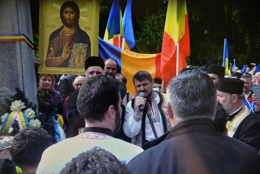 Dan Grăjdeanu vorbește mulțimii adunate în Cimitirul Valea Uzului. Foto: captură HotNews.