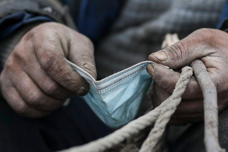 „Mihai, conducând un atelaj încărcat cu bucăți de metal și resturi de materiale de construcție, se pregătește să își pună masca, în Sintești, Ilfov.” <em>Inquam Photos / Octav Ganea</em>
