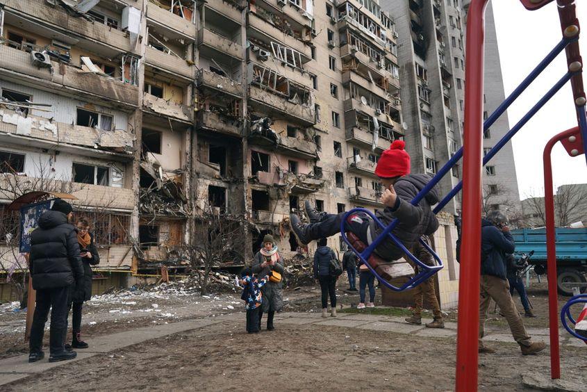 Kiev, Ucraina. O fetiță se dă în leagăn lângă un bloc distrus de căderea unei rachete rusești. Foto: Wolfgang Schwan - Anadolu Agency