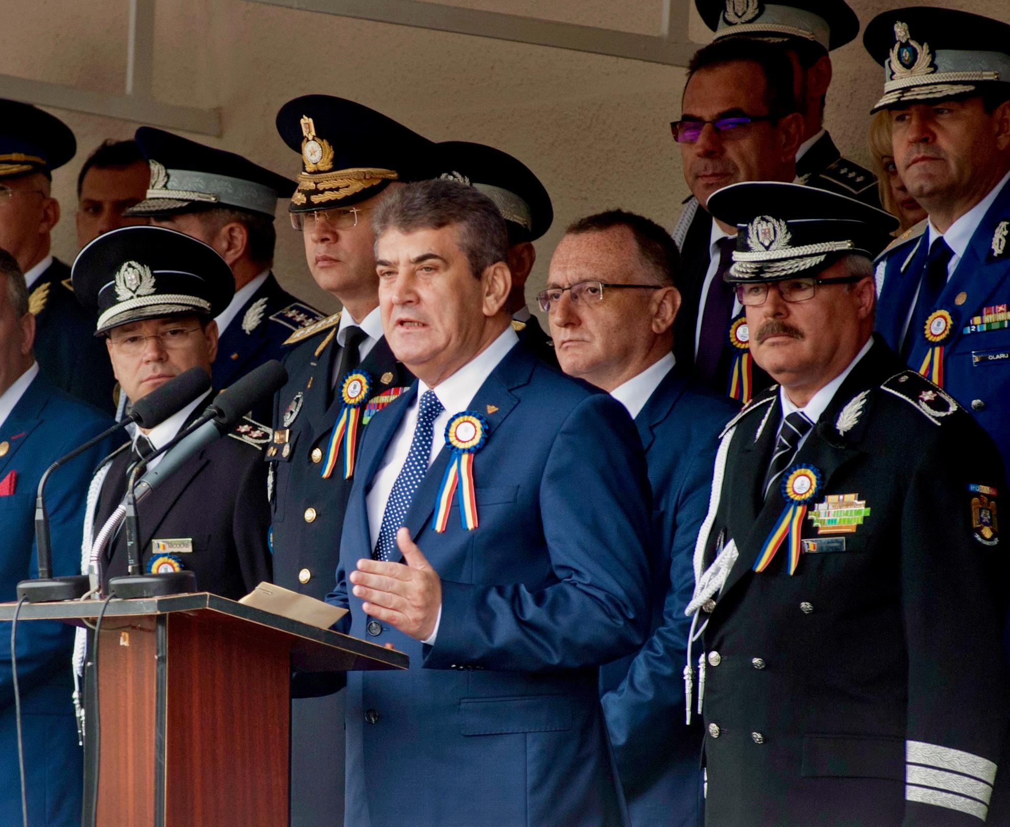 Gabriel Oprea, unul dintre arhitecții plagiatului pe scară industrială în învățământul superior de poliție, militar și de intelligence – și plagiator dovedit – ținând un discurs în timpul ceremoniei de depunere a jurământului la Academia de Poliție (2015). Între spatele său, ministrul de atunci al Educației, Sorin Cîmpeanu – care ocupă, astăzi, aceeași funcție – și care propune, la fel ca în 2015, noi portițe de salvare a plagiatorilor. Cîmpeanu, vicepreședinte al PNL, este în continuare <a target="_blank" href="http://www.assn.ro/membri/">"academician" în Academia de Științe ale Securității Naționale al cărei co-fondator este Oprea</a> – și încasează, "pe viață", o indemnizație lunară viageră. FOTO: Ilie Bumbac / AGERPRES