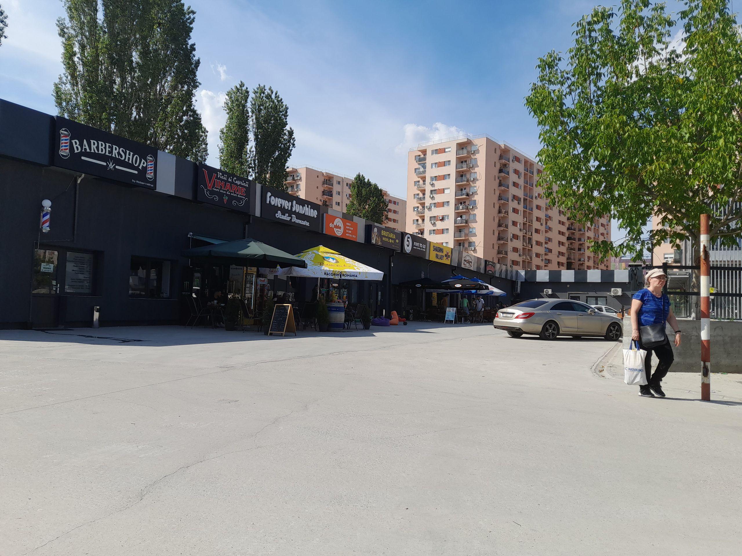 Vizavi de complexul Palladium e un mini-centru comercial cu shaormerii, brutării, cafenele și frizerii. Când bei o bere la un local de aici, priveliștea e dezolantă: beton, mașini și multe șantiere