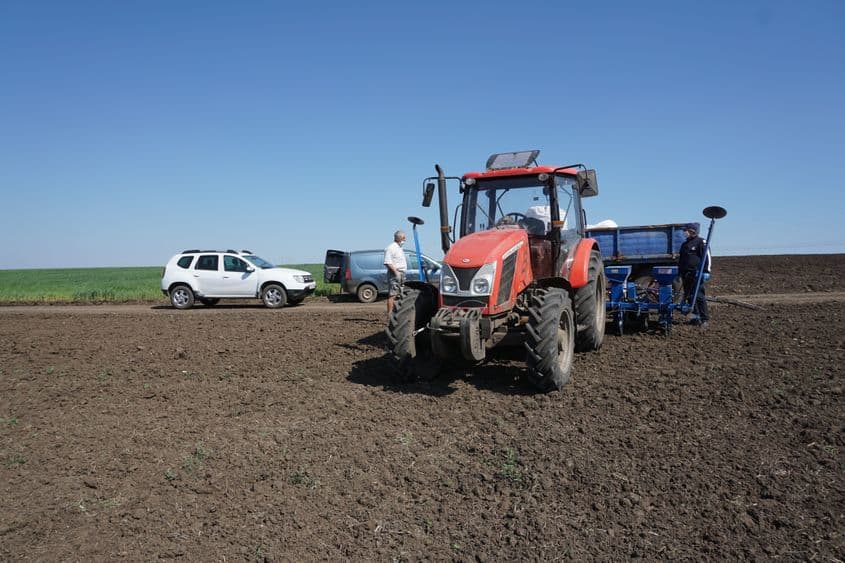 Dan Pitiș (stânga) și Florin (dreapta) asistă la semănatul pământului, respectând măsurile de protecție. Foto: Maria Tufan