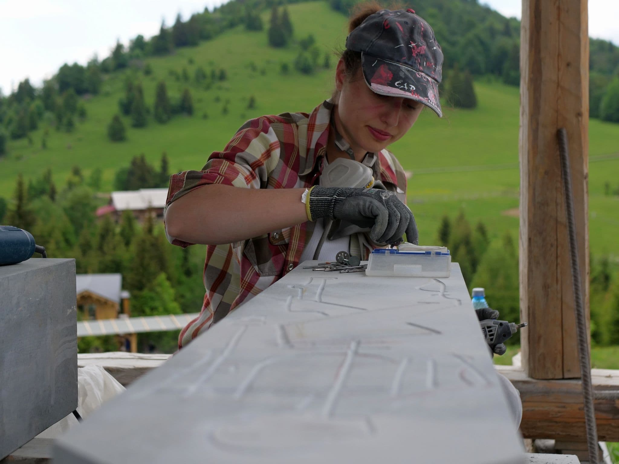 Iuliana alege un burghiu, pe fundalul culmii Tășuleasa.