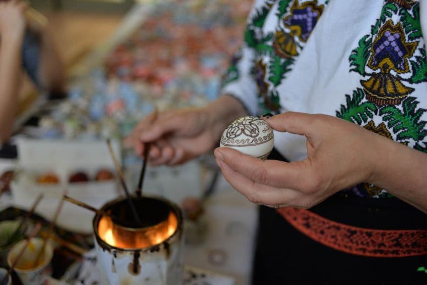 Ileana Hotopilă folosește ceară neagră, încălzită de un bec de 75W, pentru a trasa conturul simbolurilor pe care le pictează.