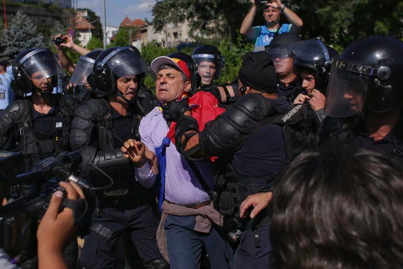 „Un bărbat este oprit de jandarmi din încercarea acestuia de a intra în curtea Guvernului în primele ore ale protestului îndreptat împotriva guvernului PSD, în Piața Victoriei, vineri, 10 august 2018.” <em>Inquam Photos / Octav Ganea</em>