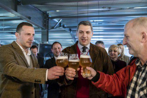 Trimis de la Budapesta, Lázár János (în centru) ciocnește un pahar de bere cu Lénárd András (în stânga) la sediul fabricii din Sânsimion. Sursa foto: kormany.hu