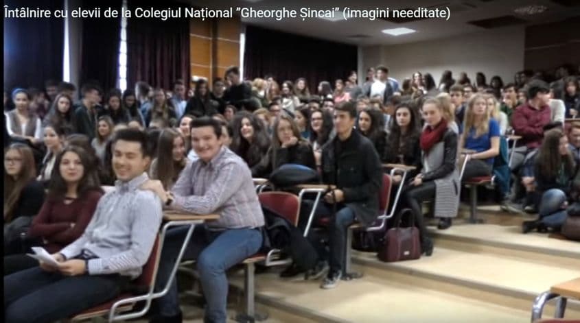 Șerban Rusu (în rândul doi, cu blugi albastru deschis) zâmbește la cameră. Captură video din întâlnirea de luni, 16 noiembrie.