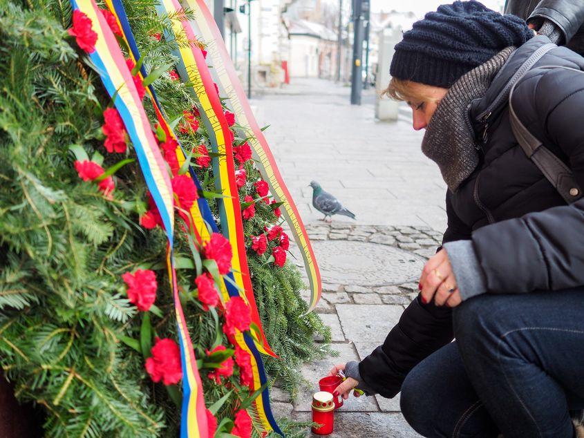 Mia Prodan aprinde o lumânare în memoria tatălui ei, lângă fosta fabrică de bere din Cluj. Fotografii: Raul Ştef