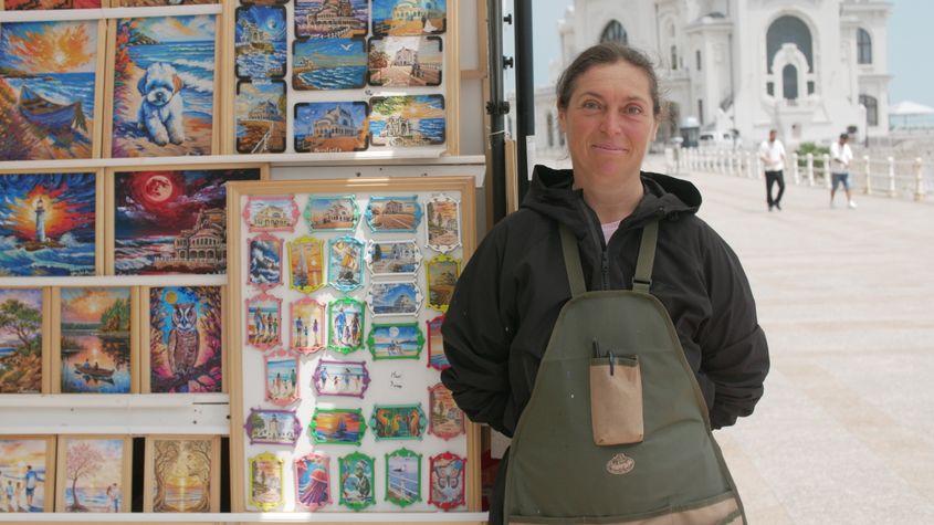 Maria Țolan, artistă, în fața standului unde își vinde picturile. Foto: Oana Moisil / PressOne