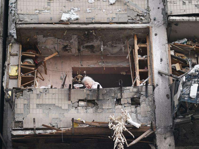 O femeie în vârstă încearcă să strângă ce mai poate din apartamentul său bombardat de forțele rusești. Kiev, Ucraina. (Wolfgang Schwan - Anadolu Agency)