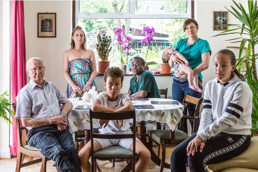 Familie din Polonia, Rwanda, Jamaica și Guyana: Annabella Dudziec (a doua din stânga), copiii ei − Izabella Dudziec-Mabasi și Lorenzo Dudziec-Mabasi (așezați, în prim-plan), partenerul ei − Nasir Brown (așezat, în planul doi), tatăl ei − Antoni Dudziec, sora ei − Magda Dudziec și bebelușul acesteia − Kuba Lois Azamat. Annabella Dudziec s-a născut în sudul Londrei, din părinți polonezi. După încheierea studiilor la Leeds, a călătorit timp de 10 ani, ajungând și în Rwanda, unde a lucrat ca profesor voluntar. Acolo l-a cunoscut pe fostul ei soț, Steve. S-au întors la Londra, s-au căsătorit și au avut doi copii, Izabella și Lorenzo. După divorț au locuit în casa părintească timp de 9 ani. Acum locuiesc vizavi, iar Steve, cu câteva case mai jos. Foto: Chris Steele-Perkins